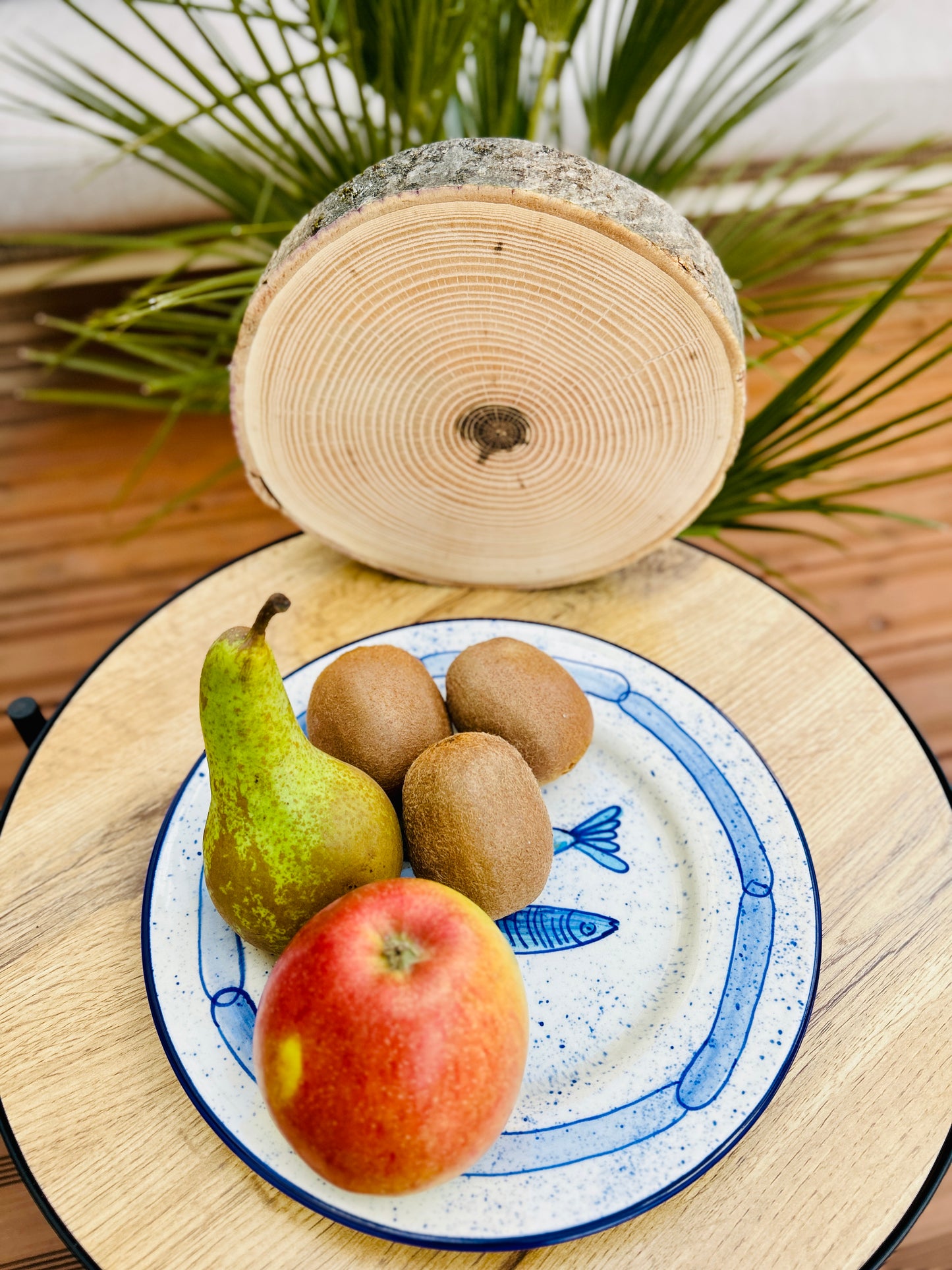 Handgemachter Keramikteller (25 cm) mit handgemaltem Motiv zweier stilisierter Sardinen in verschiedenen Blautönen auf cremeweißem Grund mit blauen Sprenkeln und kettenartigem, blauem Rand.