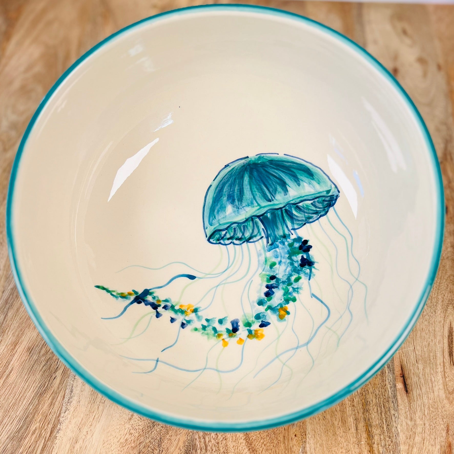 Handgemachte Keramikschale (28 cm) mit außen türkiser Glasur und kunstvoll handgemaltem Quallen-Motiv in Blau-, Türkis- und Grüntönen mit geschwungenen Tentakeln und feinen Details auf weißem Grund.