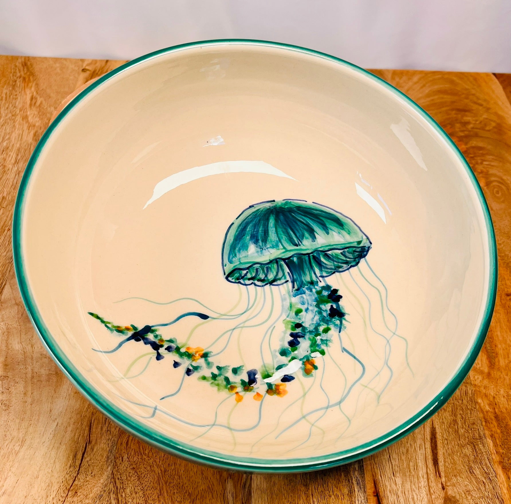 Handgemachte Keramikschale (28 cm) mit außen türkiser Glasur und kunstvoll handgemaltem Quallen-Motiv in Blau-, Türkis- und Grüntönen mit geschwungenen Tentakeln und feinen Details auf weißem Grund.