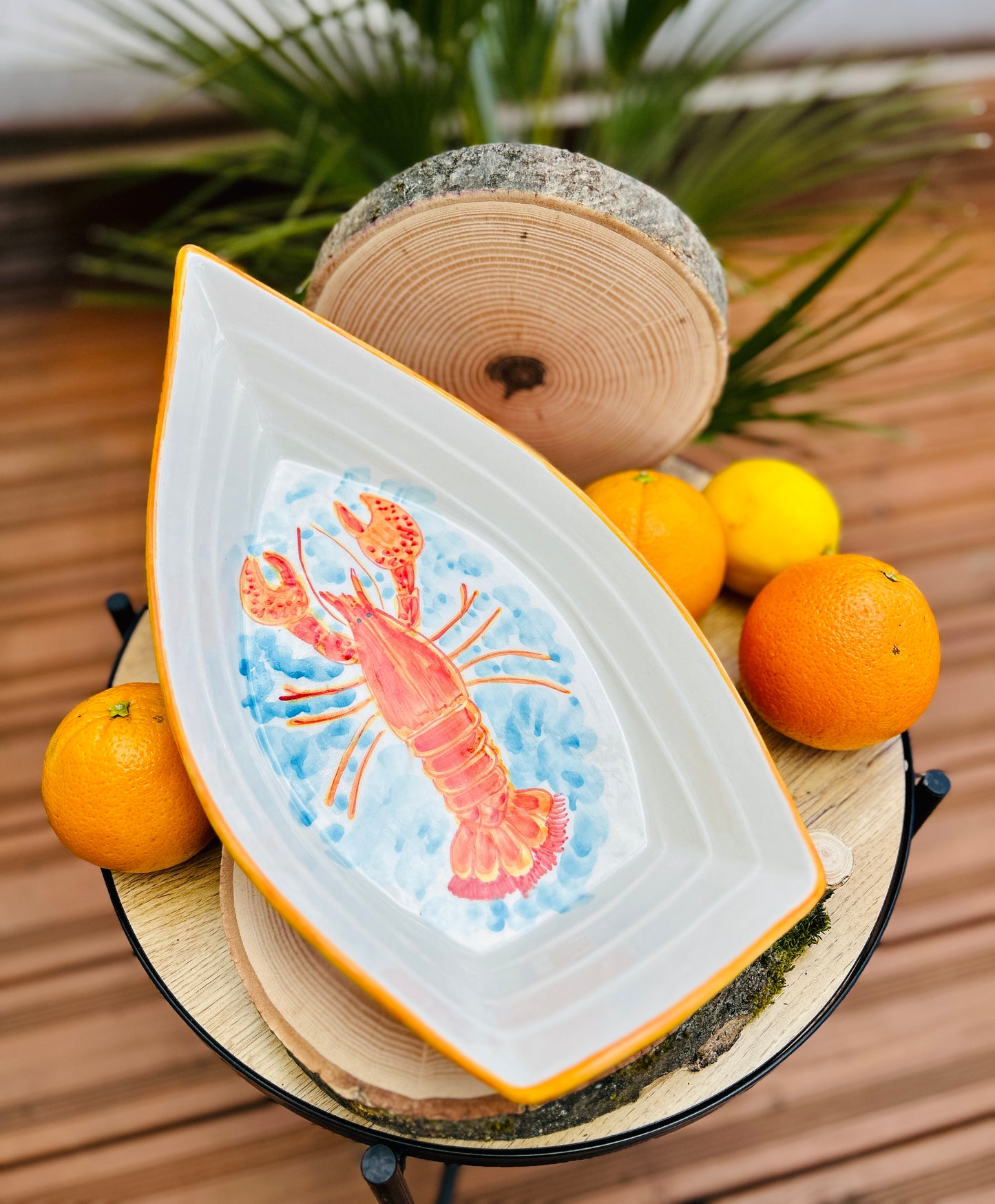 Handgemachte Keramikschale in kreativer Bootsform (34 cm) mit detailreich handgemaltem, leuchtend orangem Hummer-Motiv, geschwungenen Linien und zarten blauen Wasserakzenten auf weißem Grund.